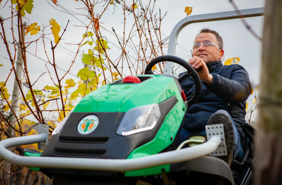 Man on Outback Rider at an orchard in autumn closeup low angle