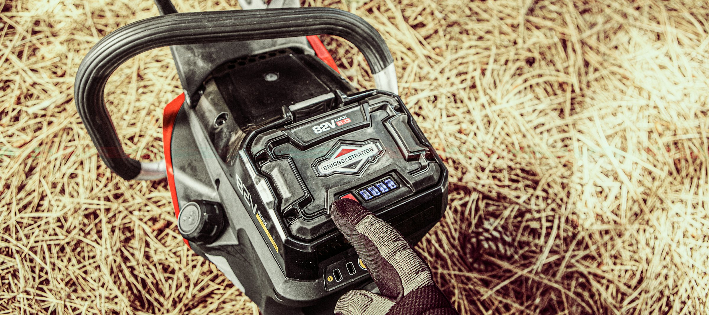 Gloved hand pointing at a 82V lithium-ion battery