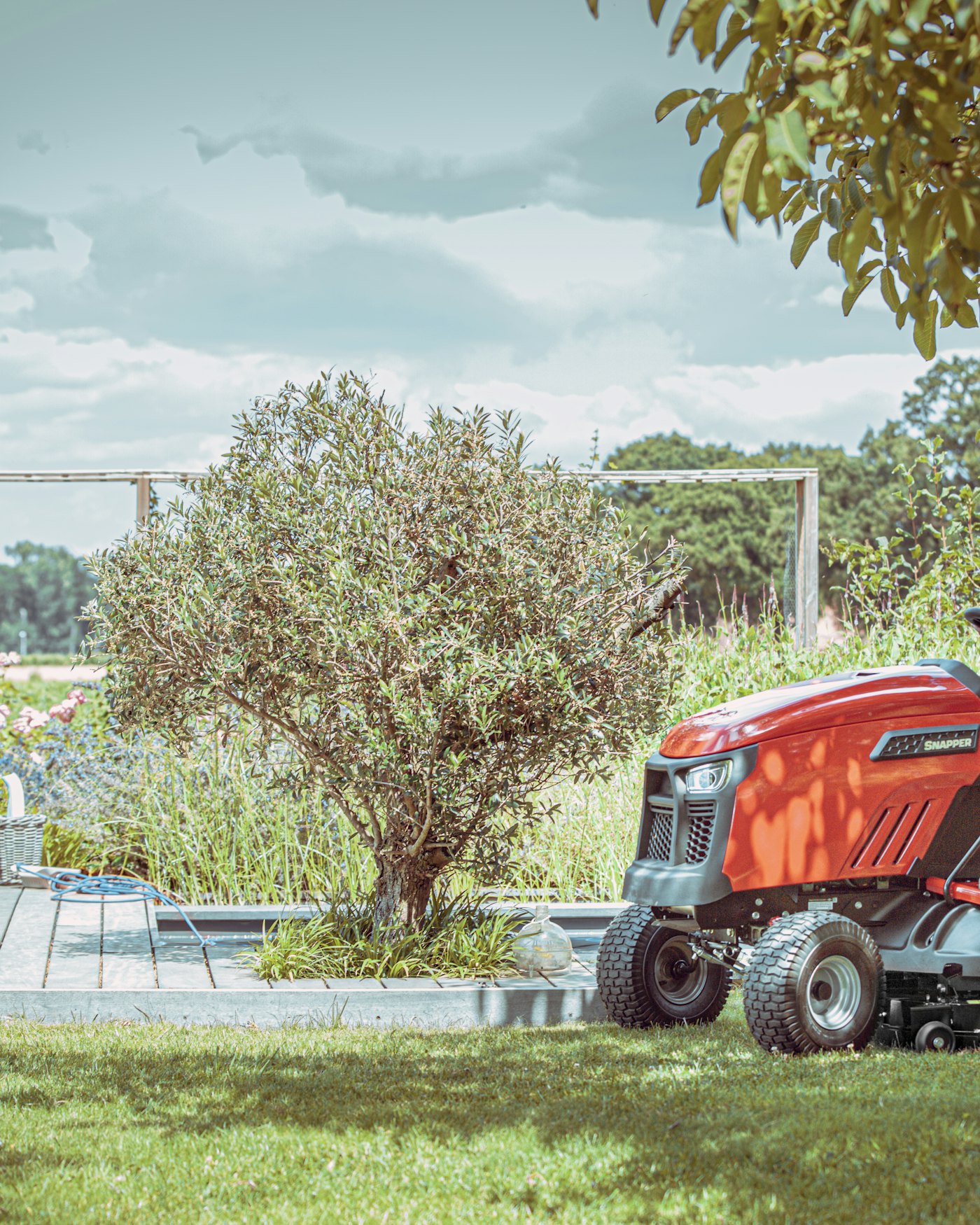 Vrouw maait gras op tuintractor met achteruitworp
