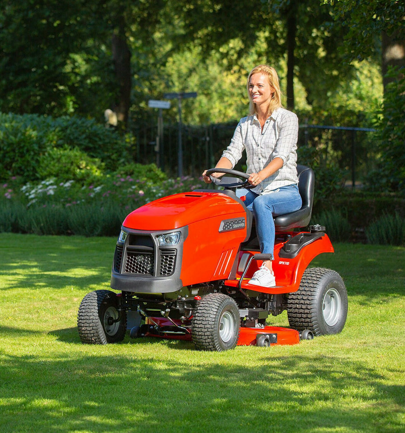 Vrouw maait gazon met tuintractor SPX110